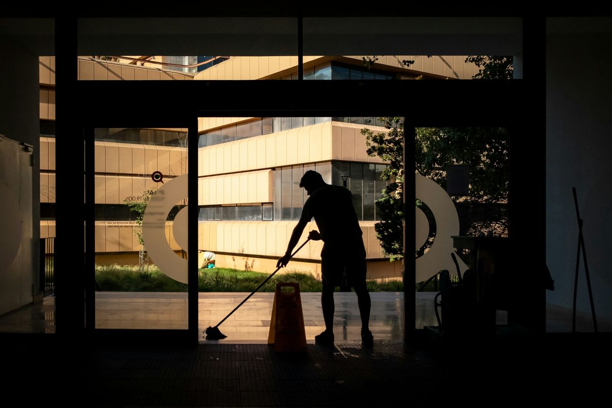 Cleaning a floor after hours, lit from outside